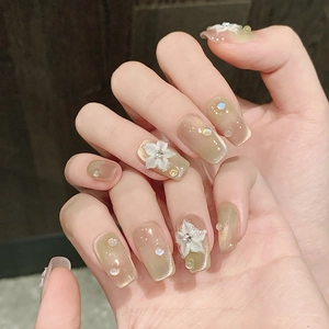 Detail of peach lime gradient cat eye press-on nails with 3D floral and pearl accents