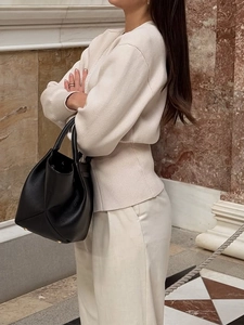 Elegante maglione beige in maglia con scollo a V e pantaloni a gamba larga color bianco crema