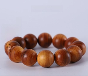 Macro detail of natural sandalwood beads showing smooth texture and wood grain