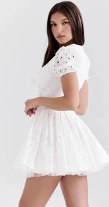 Détail de la broderie en dentelle blanche et texture florale sur robe courte à col en V