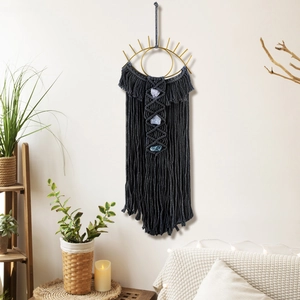 Detail of dark grey boho tapestry with blue crystals and a golden evil eye frame