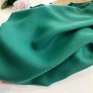 Close-up of soft green cotton linen fabric texture with natural drape and elegant sheen