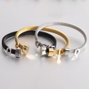 Close-up of three-color braided mesh cable bracelets in black, gold, and silver finishes
