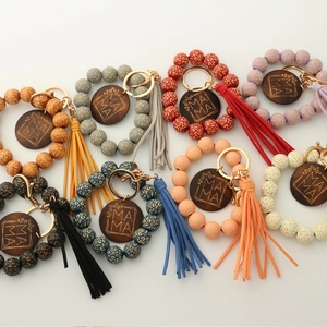 Close-up of leopard print wood bead keychains with colorful tassels and MAMA engraving