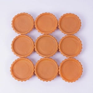 Set of 9 realistic PVC egg tart molds in orange-brown color with wavy edges on white background