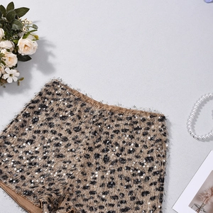 Close-up of leopard print sequin shorts with plush texture on minimal background