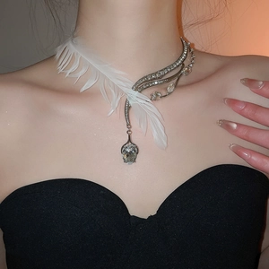 Détail du collier plume asymétrique avec cristaux brillants et pierre en forme de poire