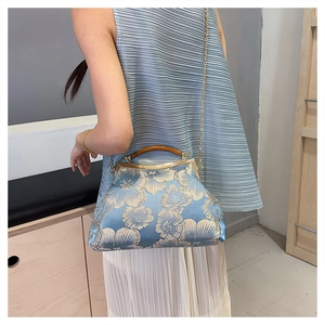 Detail of vintage blue satin evening bag with gold floral embroidery and wood handle
