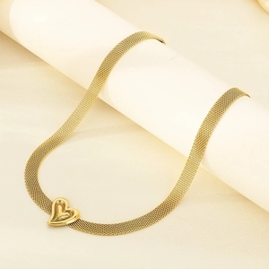 Detail of a gold mesh chain necklace with heart pendant on a white display stand