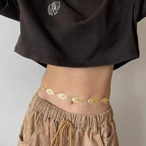 Detail view of retro gold waist chain with engraved oval metal plates on model waist