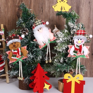 Detail von Plüsch-Weihnachtsbaum-Anhängern mit Weihnachtsmann, Hirsch und Metallglocken