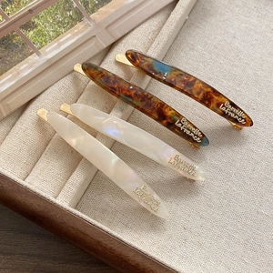 Detail of four-piece acetic acid hair clip set with tortoise and pearl white finish