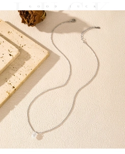 Detail of S925 sterling silver chain with a round zircon pendant on a textured background