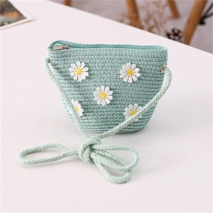 Detail of light mint green straw bag with white daisy embroidery and woven strap