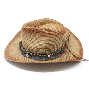 Close-up of woven straw cowboy hat with ethnic beads, tassels and embroidery detail