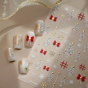 3D Christmas embossed nail stickers featuring white snowflakes and red bow designs