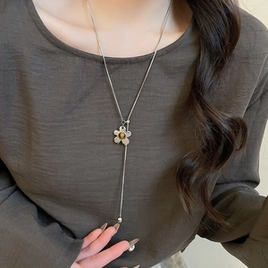 Detail of silver long tassel necklace with a five-petal flower and tiger eye stone inlay
