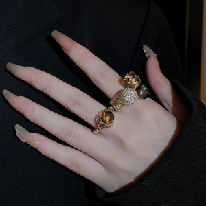 Detail of vintage gold plated rings set with cat-eye stone and rhinestones on fingers
