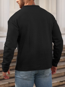 Outdoor shot showing the detailed cable knit texture on the back of a black men's sweater