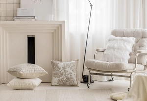 Detail of plush beige cushions with artistic tree branch patterns in a bright cozy living room