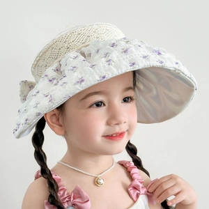 Détail d'un chapeau de soleil floral pour enfant avec dentelle et grand nœud violet