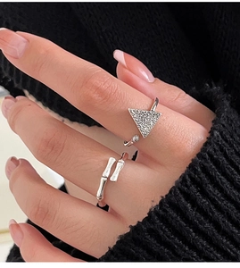 Detalle de anillos de plata s925 con diseño de bambú y triángulo puestos en el dedo