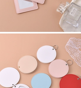 Flat lay of colorful PU leather portable mini mirrors in pink, white, beige and blue