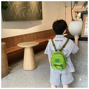 Sac à dos enfant vert léger avec bretelles réglables, porté par un petit garçon