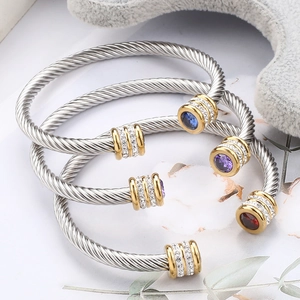 Close-up of twisted cable bangles with colorful gemstones and diamond accents
