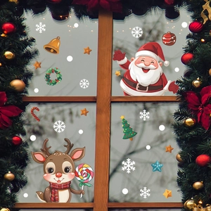Christmas window decals with Santa Claus and reindeer on a glass pane with festive pine needles