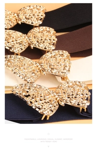 Close-up of women elastic belts with large gold butterfly buckles in four colors