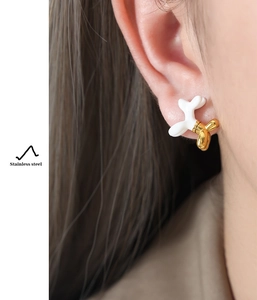 Detail of a gold-plated stainless steel balloon dog earring worn by a model