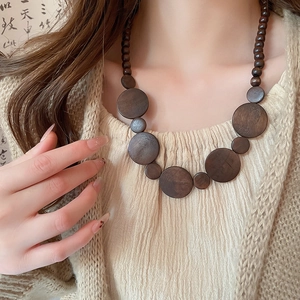 Detailed view of handmade vintage wooden bead necklace with geometric circular pendants