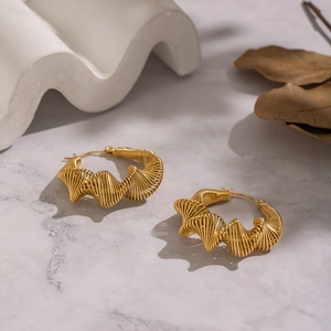 Vintage irregular geometric gold hoop earrings with spiral twisted design on marble surface