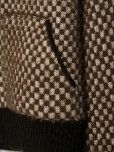 Detailed macro view of the checkered knit bomber jacket with ribbed hem and texture