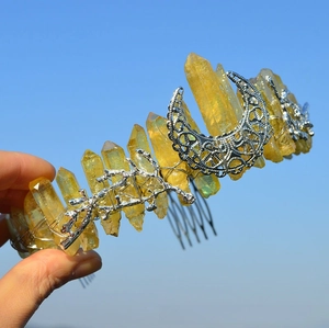Detailed shot of yellow crystal crown featuring silver moon and tree branch details