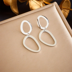 Detail of silver irregular geometric nested hoop earrings with polished metal finish