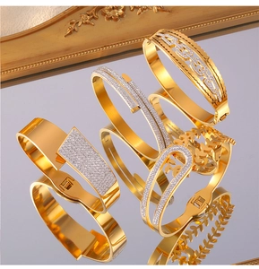 Détail macro de bracelets géométriques dorés sertis de zircons sur surface miroir