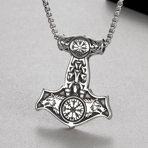 Detail of Viking Mjolnir pendant featuring wolf head relief and Norse rune compass