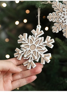 Close-up of Nordic wooden snowflake ornament held by hand with warm holiday light background