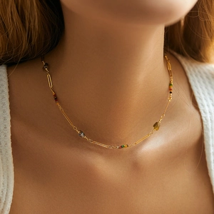 Close-up of Bohemian 18K gold beaded necklace with colorful stones on model neck