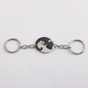Macro detail of intertwined black and silver stainless steel cat couple keychains