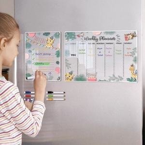Child writing on a jungle-themed acrylic weekly planner and note board on a fridge