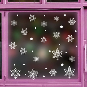 Close-up of white snowflake static window stickers in various sizes for holiday decor