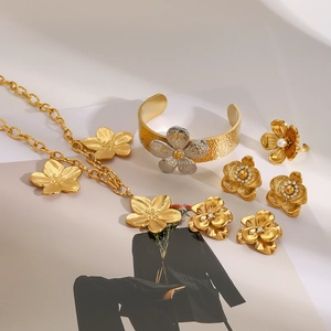 Elegant gold flower jewelry set including necklace bracelet ring and pearl earrings
