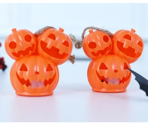 Macro view of stacked orange Halloween pumpkin lanterns with rustic hemp rope hangers