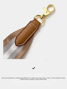 Close-up of 5cm wide striped canvas shoulder strap with brown leather ends and gold metal hooks