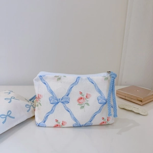 Floral cotton small storage pouch with blue bow and pink rose pattern on white desk