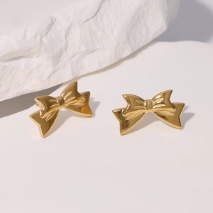 Minimalist gold-plated stainless steel bow earrings on a textured stone aesthetic background