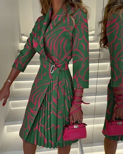 Detail of V-neck pleated dress with abstract pink prints and metal buckle on the waist